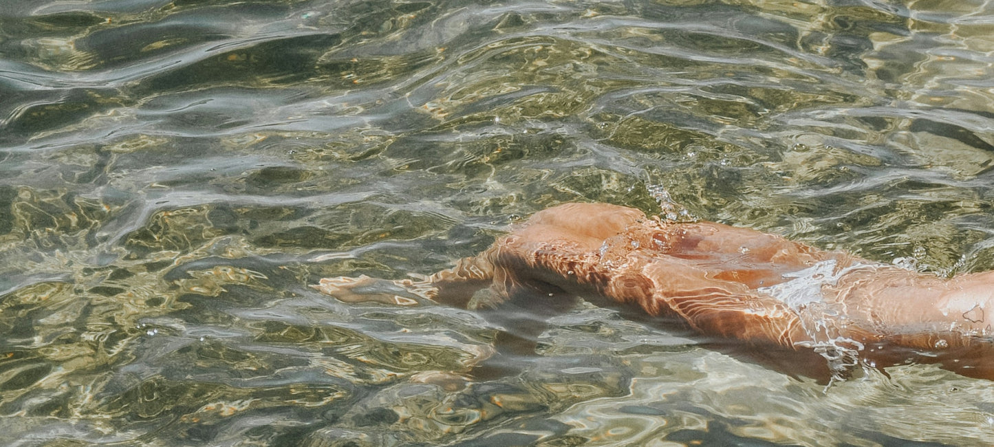 Banner image for the Faeves About Us page, featuring a woman's body gently floating on calm water, symbolizing serenity and reflection.