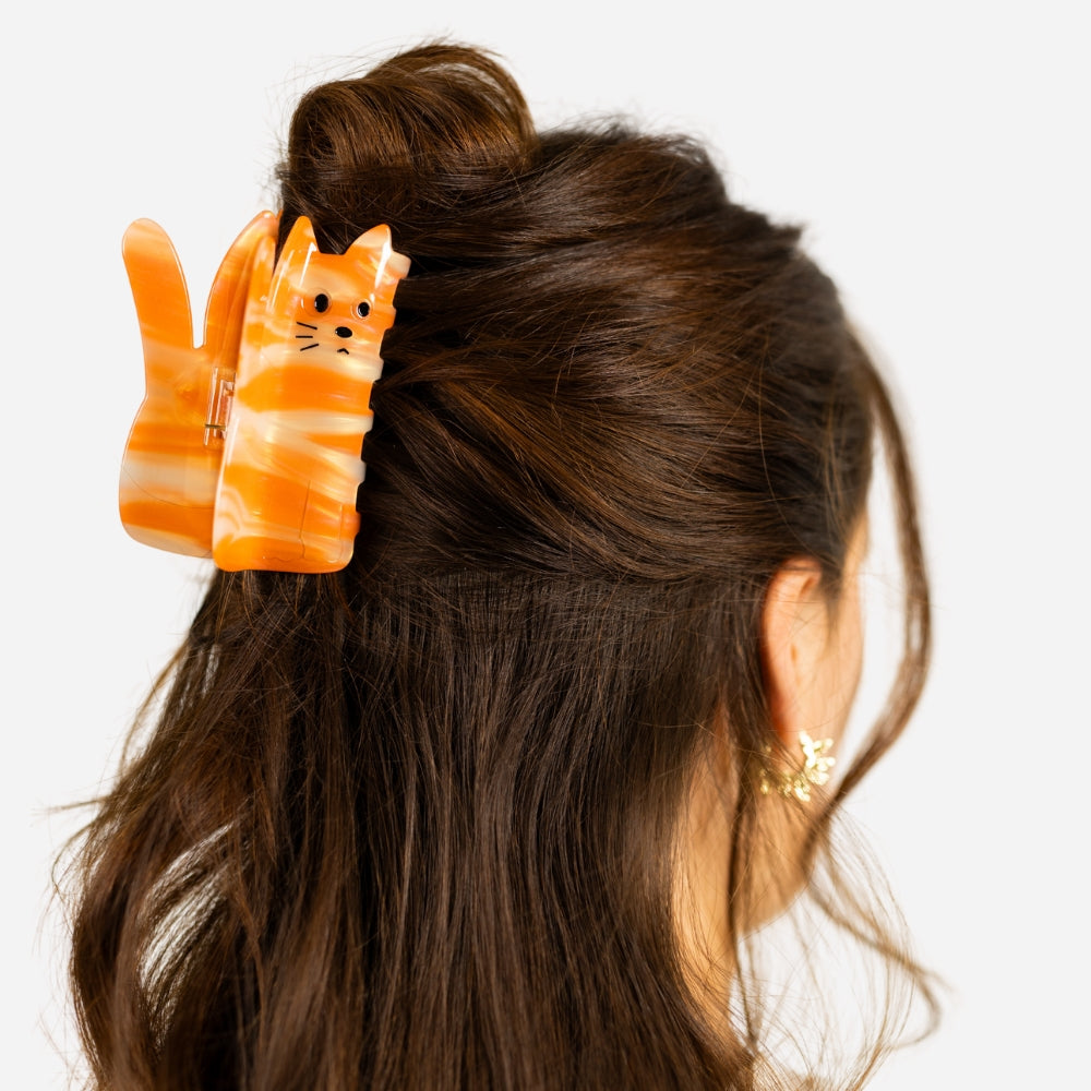 Orange cat claw clip for securing thick hair, ideal for various hairstyles