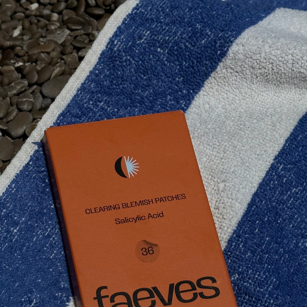 Faeves Clearing Blemish Patches resting on a striped beach towel, perfect for skincare on the go during a beach day.