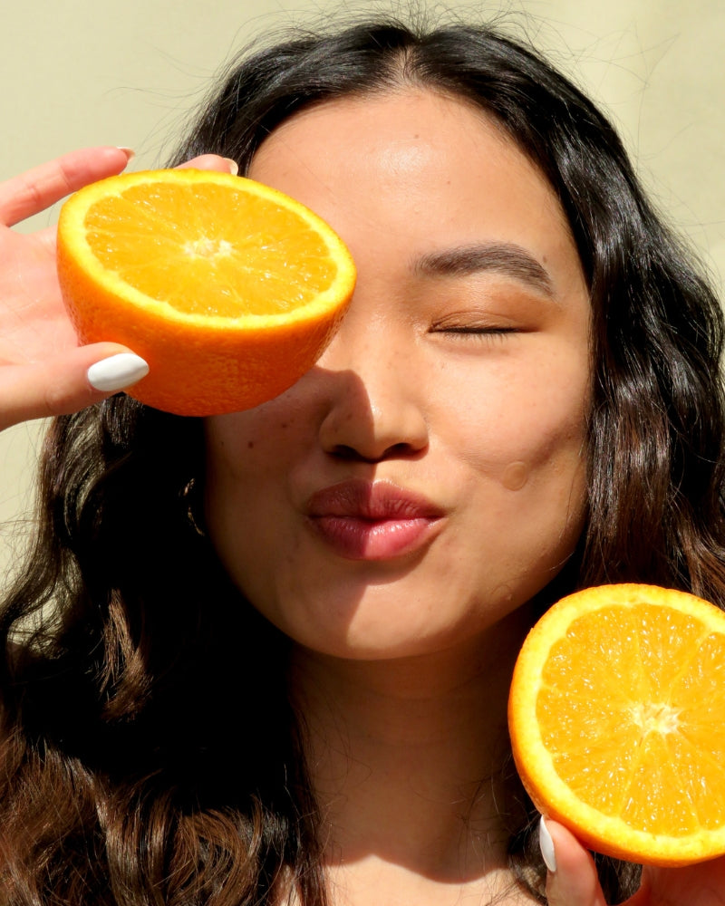 Mobile homepage banner featuring a woman holding two orange slices with a Faeves skincare patch on her cheek, emphasizing the natural and vibrant essence of Faeves.